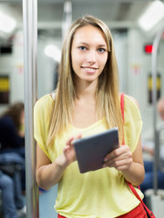 Female using ereader in subway