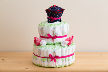 Fake layered cake made from diapers, babysocks, and a babydress