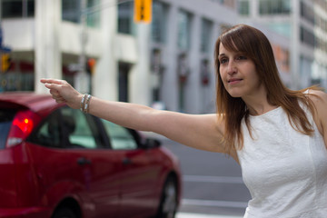 Woman hails a taxi on a downtown street