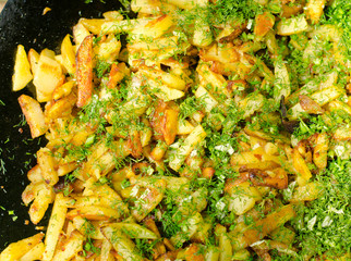 Tasty freshly cut potato chips and herbs on a BBQ