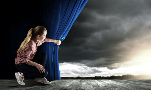Woman looking out from curtain