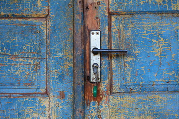 old wooden cracked blue door with handle