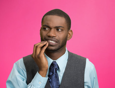 Man with tooth ache, pain isolated on pink background 