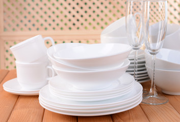 Set of white dishes on table on light background