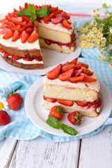 Delicious biscuit cake with strawberries on table close-up