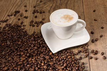 Tasse Cappuccino und Kaffeebohnen