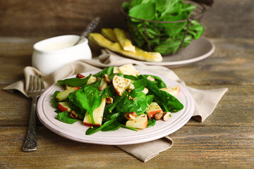 Green salad with apples, walnuts and cheese on wooden