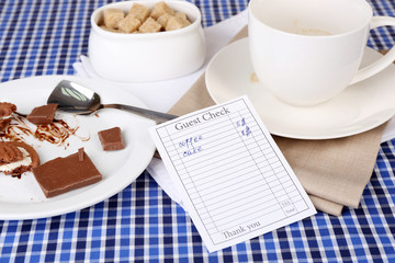 Check and remnants of food and drink on table close-up