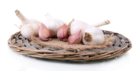 Fresh garlic on wicker mat isolated on white