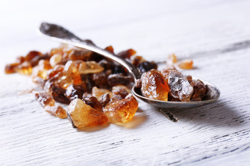Reed sugar in spoon on wooden background