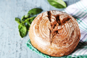 Fresh baked bread and fresh basil, on wooden background