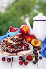Sweet berry tart with berries on table on natural background