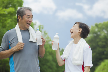 ペットボトルの水を飲むシニア