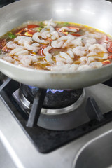 Shrimp in a cast iron skillet being sauteed.