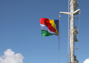 Closeup of Seychelles flag streaming in the wind on the mast of