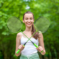 Sport woman with badminton rackets in the park