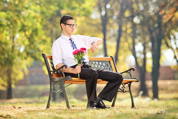 Young guy waiting for his date in park