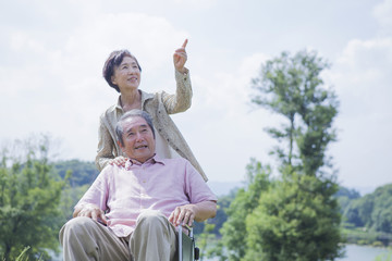 車椅子で散歩をする夫婦