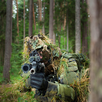 Masked soldier is aiming at the target during the mission (color