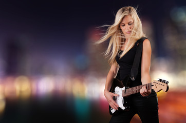 Beautiful blond girl playing on guitar