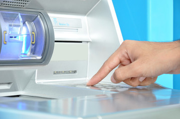 ATM (Automated Teller Machine) with hand pressing on the keypad