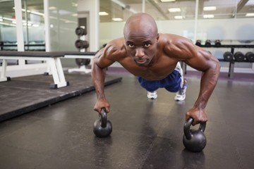 Fototapeta na wymiar Muscular man doing push ups in gym