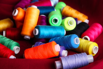 Multicolor sewing threads on color fabric background