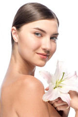 Beautiful face of the young woman with white flower