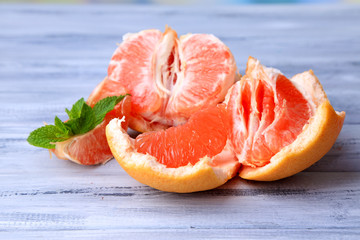 Ripe peeled grapefruits on color wooden background
