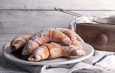 Tasty bagels with powdered sugar, on wooden background