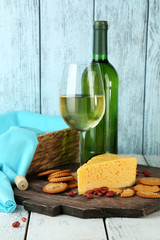 Naklejka premium Wine, cheese and crackers on wooden table close-up