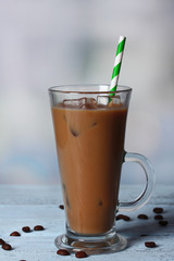 Glass of iced milk coffee on light background