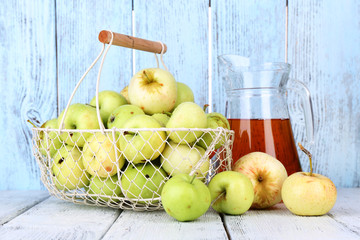 Ripe apples and juice in basket on table close-up