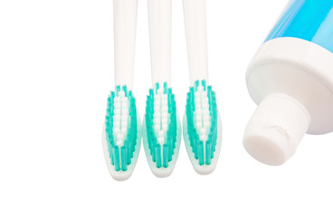 Toothbrush and toothpaste over white background