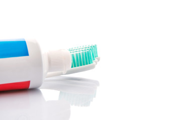 Toothbrush and toothpaste over white background