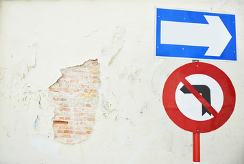 arrow traffic sign with old wall