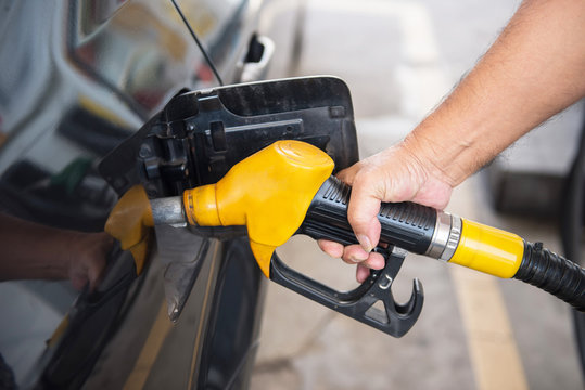 transportation concept - man pumping fuel in car at petrol stati