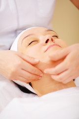 Fototapeta na wymiar Massage of face at beauty treatment salon