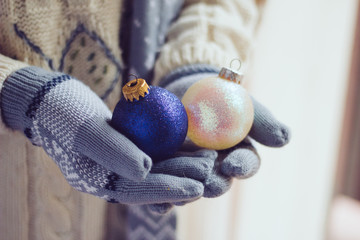 Obraz premium Woman wearing gloves and holding Christmas balls