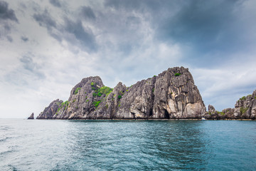 Fototapeta na wymiar Tropical rock island against blue sky and sea