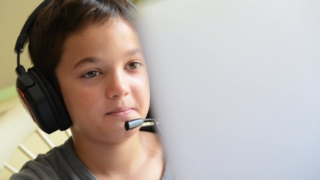 Child playing on the computer with headphones
