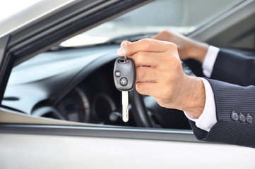 Hand holding a car key - car sale & rental business concept