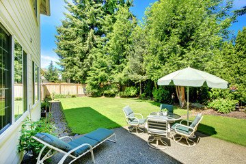 SUny green backyard with yellow hosue.