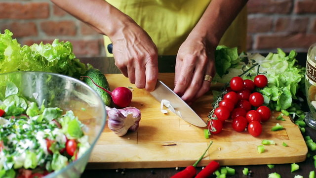 Woman cutting garlic on the chopping board, closeup