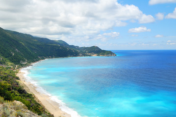 Fototapeta premium Coastal sea blue waters with beach and steep hill