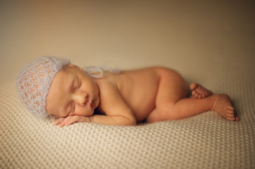 Obraz premium Portrait of Newborn Baby Sleeping in Subtile Hat on Soft Blanket