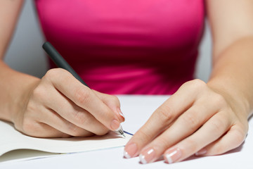 Woman's Hands Holding A Pen Writing A Text