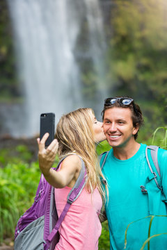 Couple having fun taking pictures together outdoors on hike