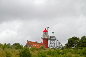 Fototapeta na wymiar Red lighthouse on dutch island Vlieland