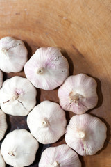 a clove of garlic and a whole wooden table closeup